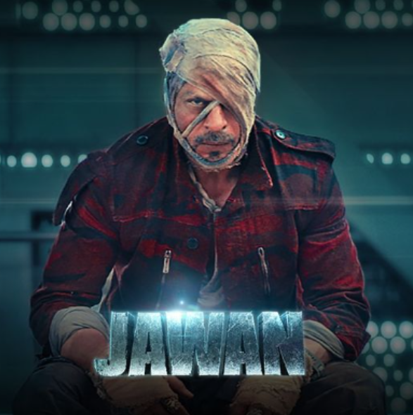 Shah Rukh Khan in a fierce, bandaged look from Jawan, donning a rugged outfit, set against a dark backdrop. The action-packed Bollywood film is produced by Red Chillies Entertainment